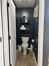 Bathroom with a textured ceiling and light tile patterned floors