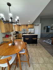 Dining room with a chandelier, light tile patterned floors, recessed lighting, and a textured ceiling