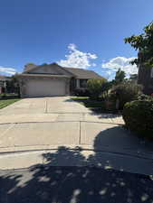 Ranch-style house with driveway, a garage, and stone siding