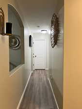 Corridor featuring wood finished floors and arched walkways