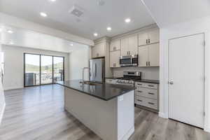 A stylish, contemporary kitchen featuring a generous island, perfect for hosting and socializing with family and friends. The open-concept layout effortlessly transitions into the living space, making it an ideal setting for both dinner parties and casual