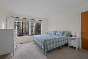 Bedroom with light colored carpet and baseboards