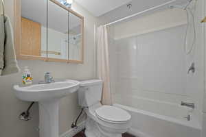 Bathroom with shower / bath combination with curtain and a textured ceiling