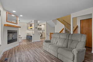 Living room featuring recessed lighting, light wood-style flooring, and stairway
