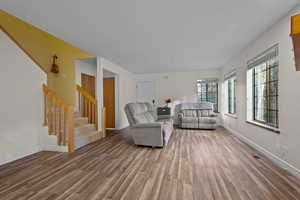 Living area featuring stairway and wood finished floors