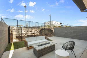 Fenced backyard with a patio area and an outdoor living space with a fire pit