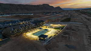 Aerial view at dusk of view of pool area, a mountain view, and a residential view