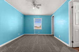 Unfurnished bedroom featuring carpet, a ceiling fan, a textured ceiling, and crown molding