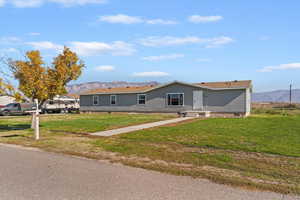 View of front of house with a mountain view, a front yard, and entry steps