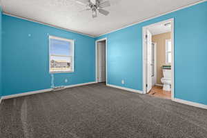 Unfurnished bedroom with carpet flooring, ceiling fan, and a textured ceiling