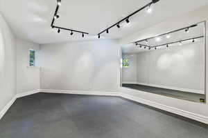 Exercise room featuring plenty of natural light and rail lighting