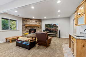 Living area featuring recessed lighting, light colored carpet, and a stone fireplace