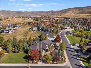 Aerial view of property and surrounding area with mountains and nearby suburban area
