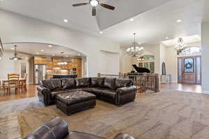 Living room featuring a chandelier, recessed lighting, arched walkways, and wood finished floors