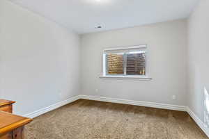 Carpeted spare room featuring baseboards
