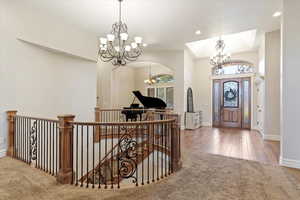 Foyer entrance featuring carpet, recessed lighting, a chandelier, and wood finished floors
