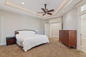Master Bedroom featuring a tray ceiling, a ceiling fan, light colored carpet, and recessed lighting