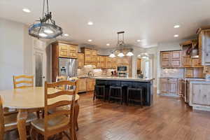 Dining room with arched walkways, dark wood-type flooring, and recessed lighting