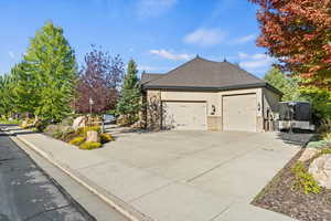 View of property exterior featuring stucco siding, concrete driveway, brick siding, and a garage