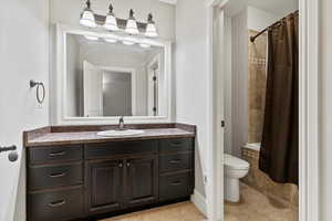 Full bath featuring vanity, light tile patterned floors, and tiled shower / bath combo