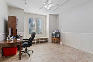 Office area featuring track lighting, wainscoting, and a ceiling fan