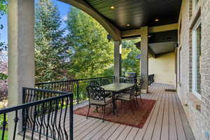 Wooden terrace featuring outdoor dining space and a grill
