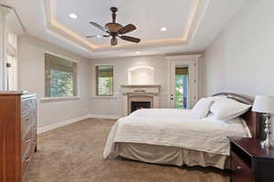 Master Bedroom with light carpet, ceiling fan, a lit fireplace, recessed lighting, and access to exterior