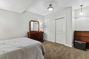 Carpeted bedroom featuring a closet and baseboards