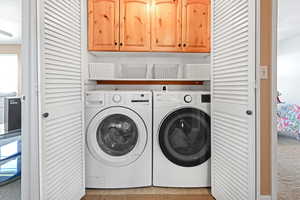 Laundry room with cabinet space and washer and clothes dryer