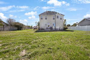 Rear view of property with a fenced backyard and a patio area