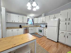 Kitchen with white cabinetry, white appliances, light wood finished floors, decorative light fixtures, and lofted ceiling