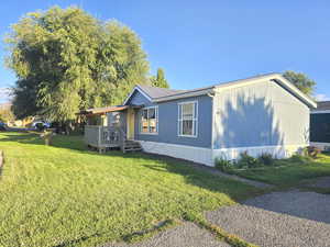 View of property exterior with a lawn and a metal roof
