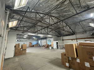 Misc room featuring lofted ceiling, a garage, and metal wall