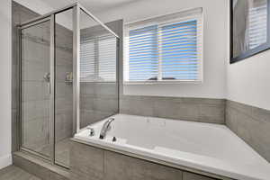 Primary suite featuring a shower stall and large tub