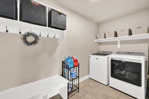 Washroom with independent washer and dryer and wood tiled floors