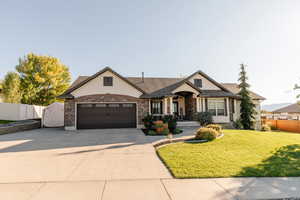 Craftsman house with driveway, stucco siding, stone siding, and a garage