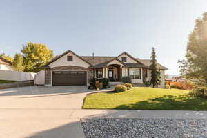 View of front of house with driveway, stucco siding, a garage, and stone siding