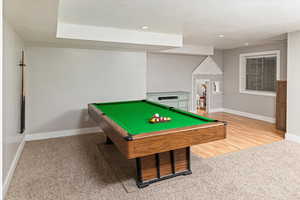 Game room featuring a textured ceiling, pool table, light colored carpet, light wood-style floors, and recessed lighting