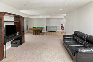 Recreation room featuring a textured ceiling, light colored carpet, recessed lighting, and billiards table