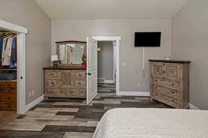 Bedroom with dark wood-style flooring and baseboards