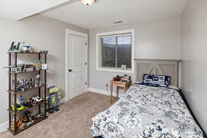 Carpeted bedroom featuring baseboards and a textured ceiling