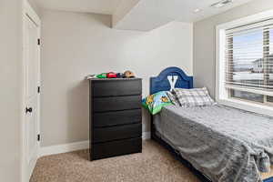 Carpeted bedroom featuring baseboards and a textured ceiling