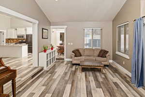 Living area featuring light wood-style flooring and high vaulted ceiling