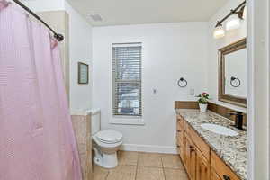 Bathroom featuring light tile patterned flooring, vanity, and a shower with curtain