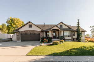 View of front of property with stucco siding, concrete driveway, and stone siding