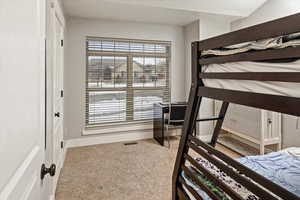 Bedroom featuring light colored carpet and a closet
