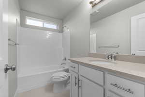 Full bathroom featuring washtub / shower combination, vanity, and light tile patterned floors