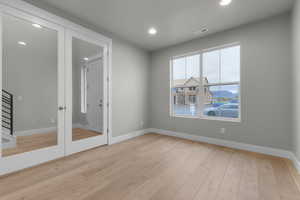 Unfurnished room featuring recessed lighting, light wood-style flooring, and a mountain view