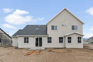 Back of house with stucco siding, roof with shingles, and a patio