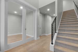 Stairway with hardwood / wood-style floors and recessed lighting